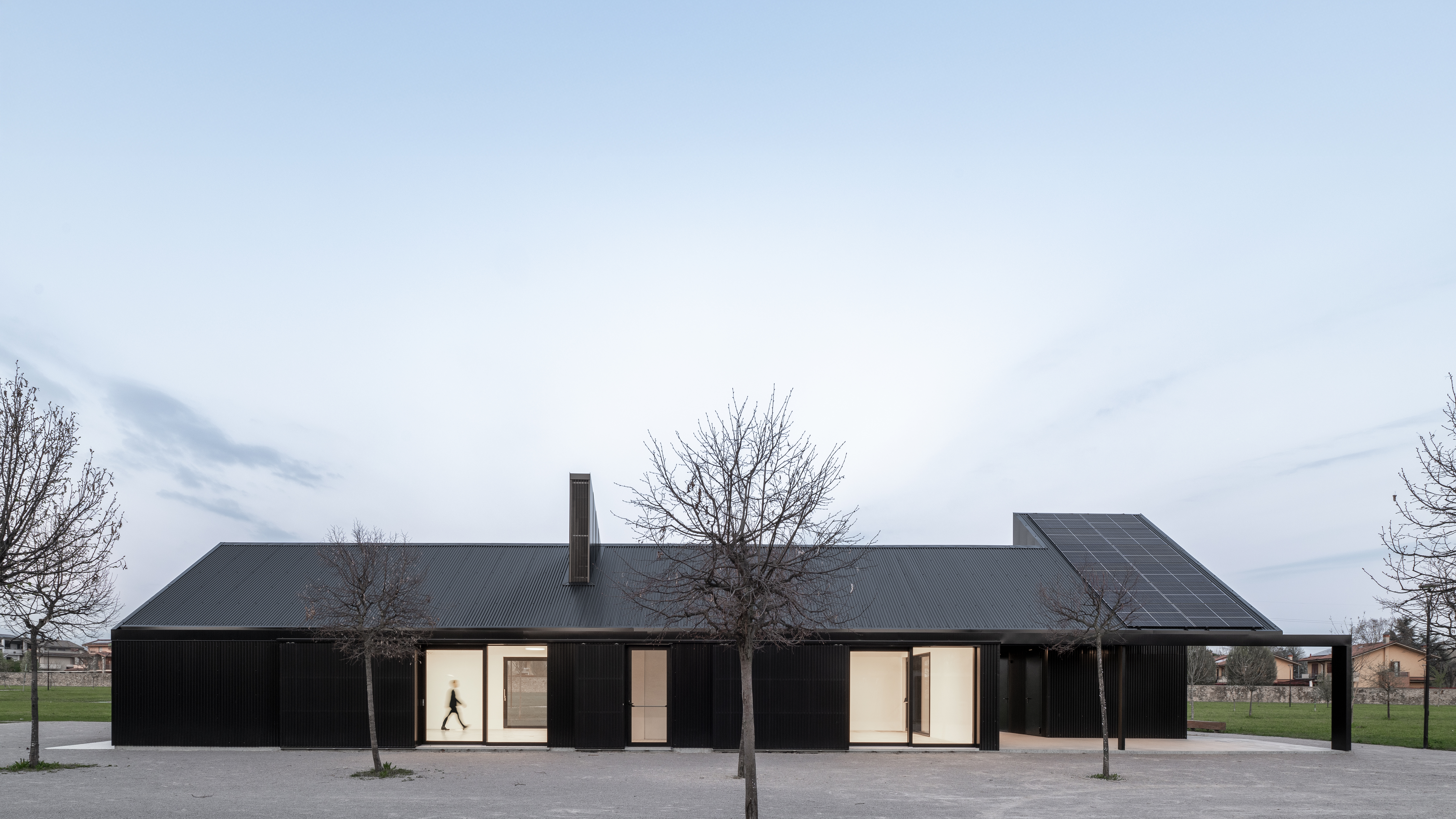 Edificio moderno in carpenteria metallica nera con ampie vetrate luminose e tetto a spiovente, Padiglione multifuzionale Parco Brolo realizzato da Fratelli Gelmini.